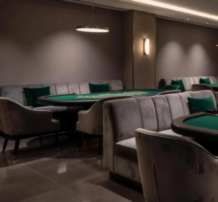 Sfeervolle interieurfoto van een Holland Casino vestiging in Amsterdam met verlichte speeltafels en warme verlichting.